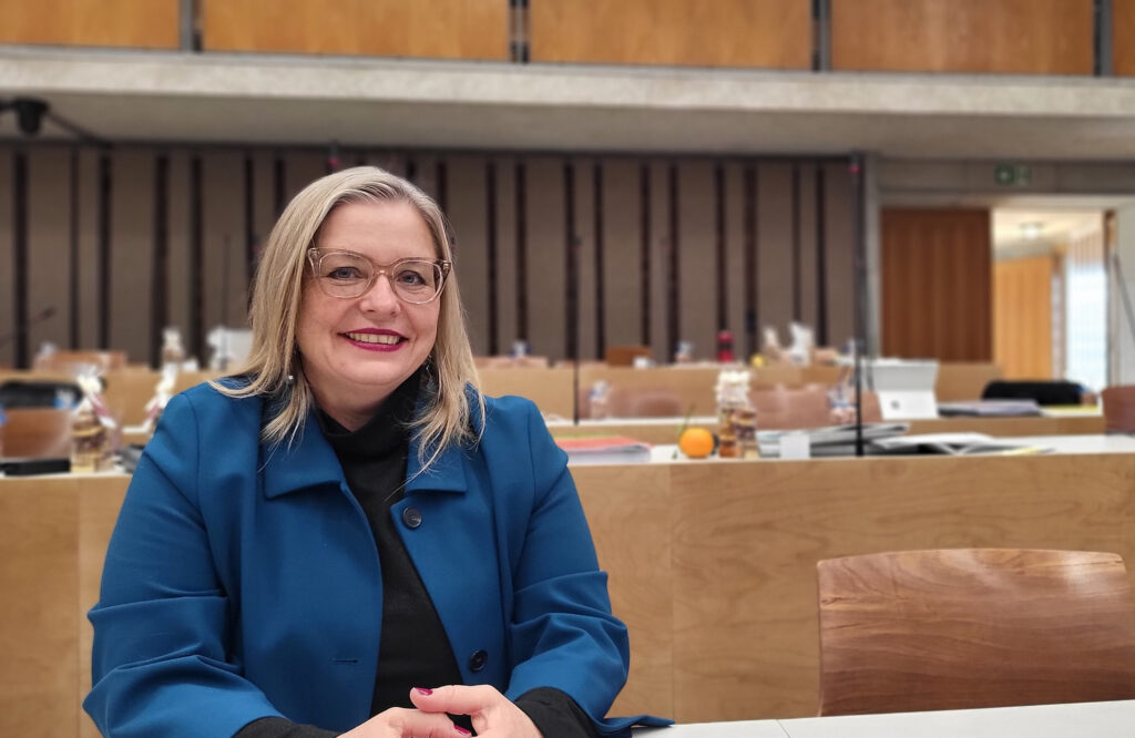 Die Mitte-Politikerin Marzena Kopp sitzt im Saal des Gemeinderats im temporären Rathaus Hard. Sie trägt eine Brille und einen blauen Blazer.