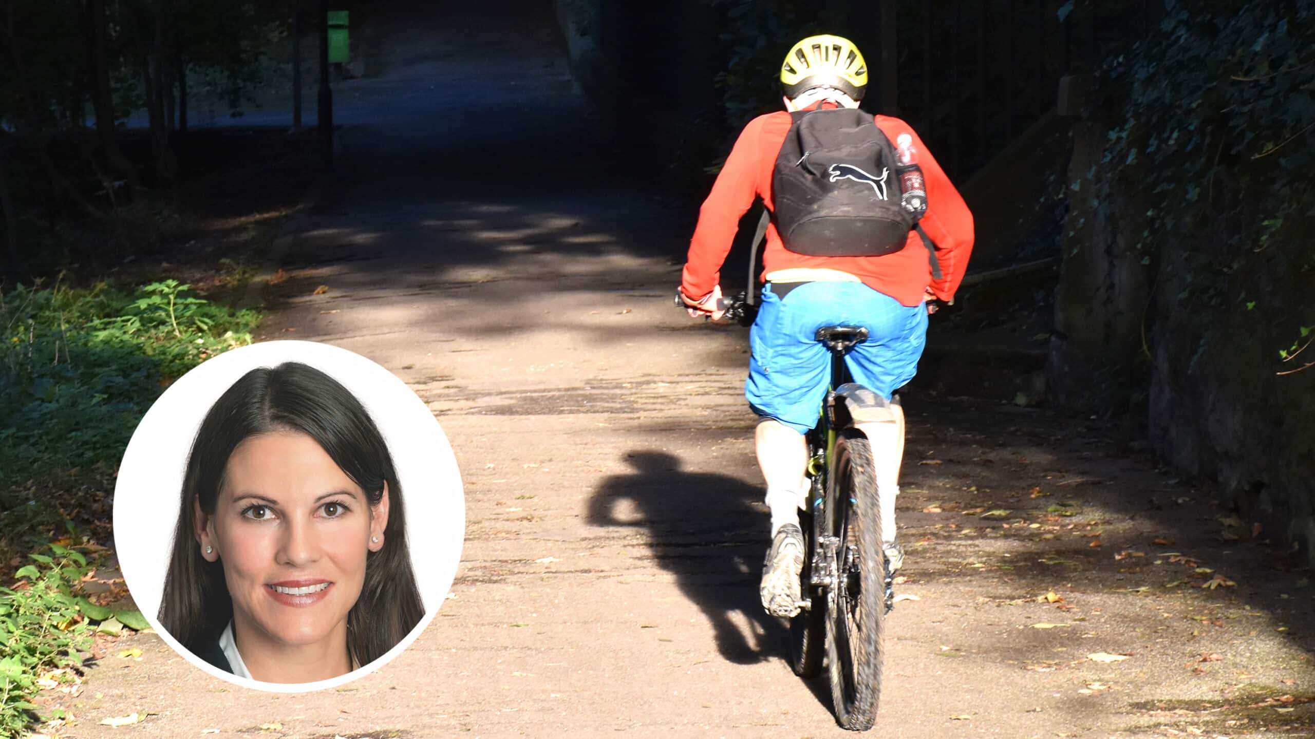 Im Hintergrund fährt ein Mann auf einem Mountainbike einen schmale Strasse hoch. Im Vordergrund ist ein Porträtfoto von SVP-Politikerin Nina Fehr Düsel platziert.