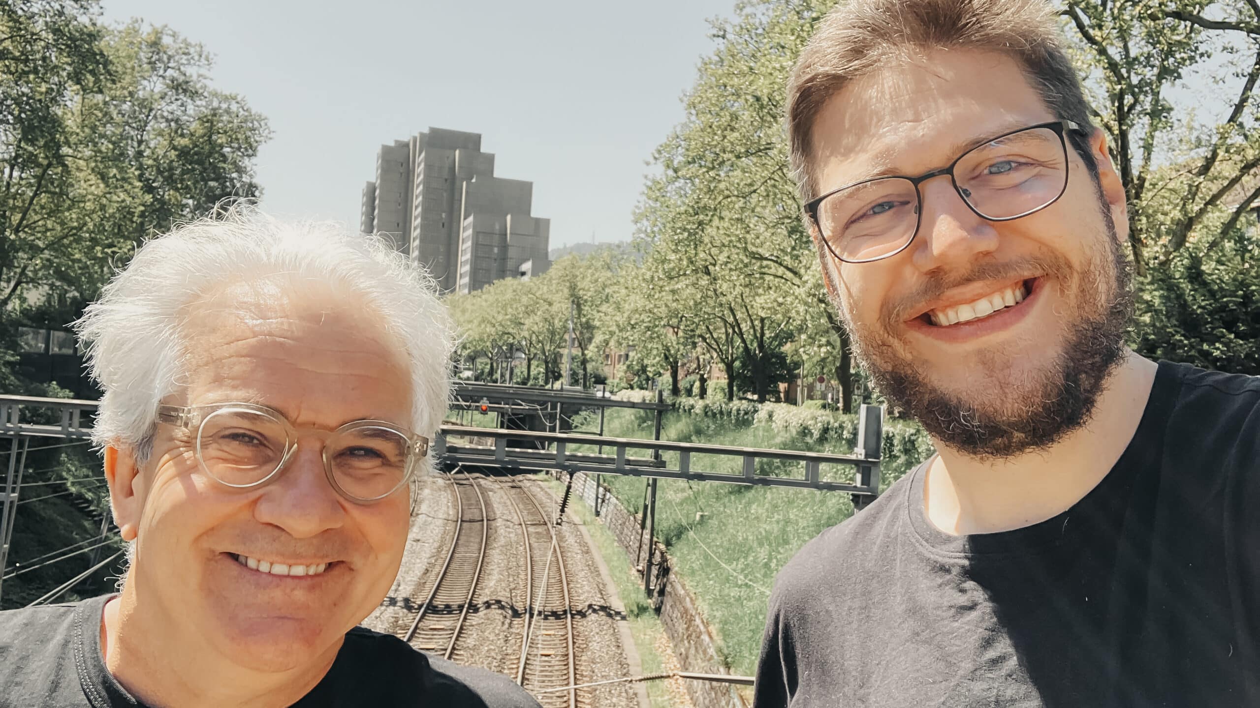 Selfie der Rathuus-Gründer Lorenz Steinmann und Pascal Turin. Im Hintergrund sind die Gleise der linksufrigen Zürichseebahn sowie die Türme der Wohnsiedlung Lochergut zu sehen.