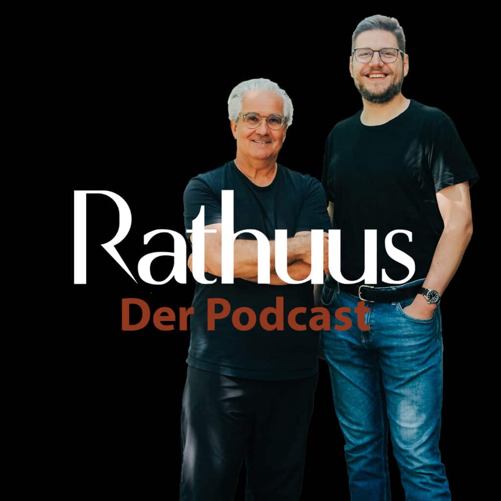 Lorenz Steinmann und Pascal Turin posieren ausgeschnitten auf schwarzem Hintergrund. Im Vordergrund ist das Rathuus-Logo sowie der Schriftzug "Der Podcast" platziert.