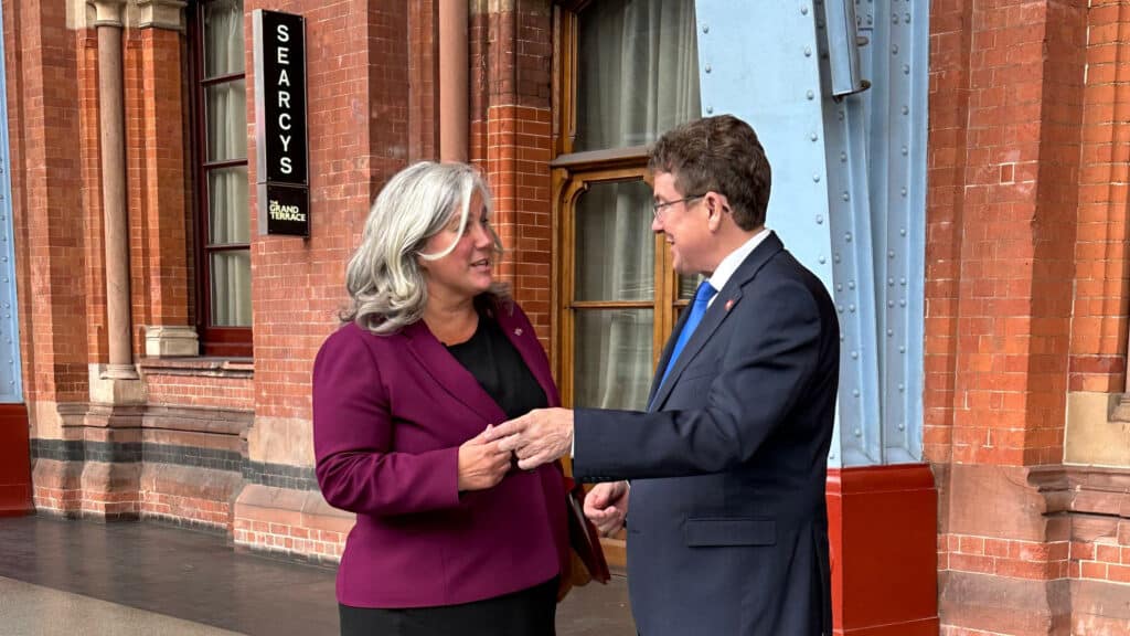 Bundesrat Albert Rösti und die britische Transportministerin Heidi Alexander sprechen miteinander. Beide tragen formelle Businesskleidung.