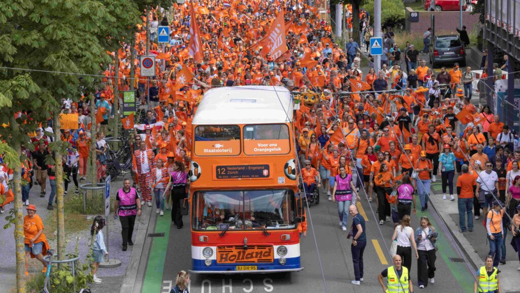 Riesiger Fanmarsch durch Zürich. Die Fans der niederländischen Nationalmannschaft sind alle in orange gekleidet und gehen in Richtung Letzigrund. Der Fanmarsch wird von einem doppelstöckigen orangen Fanbus angeführt.