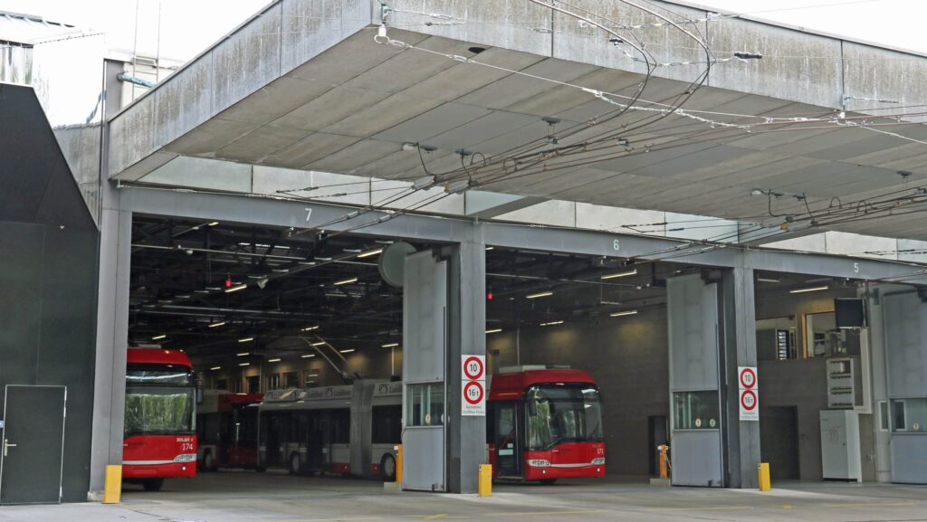 Das Bild zeigt das Busdepot Grüzefeld. Die Tore sind geöffnet und man sieht die für Winterthur typischen rot-weissen Busse.