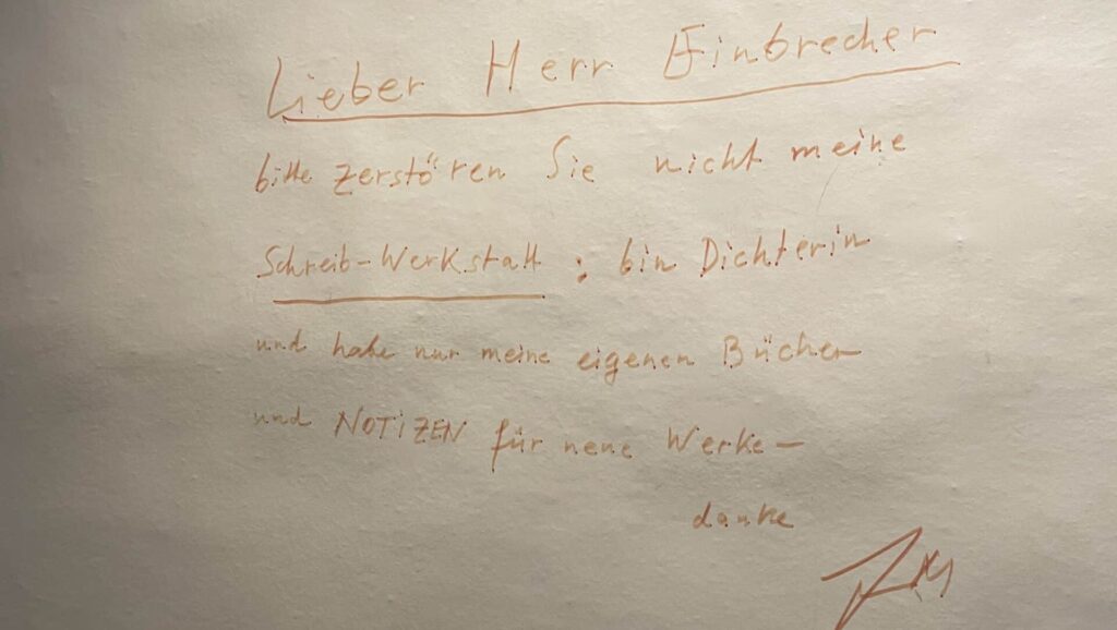 Auf dem Bild ist eine Notiz der Schriftstellerin Friederike Mayröcker (1924–2021) zu sehen. Es geht um eine Info an einen Einbrecher.