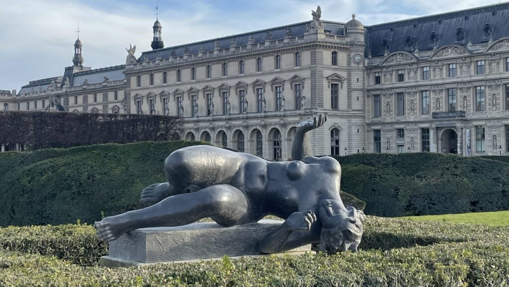 Zu sehen ist eine Frauenskulptur vor dem Louvre.