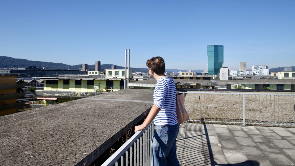 Hier ist SP-Gemeinderatskandidat Jascha Harke zu sehen, die er in Richtung Zürich-West schaut, vom Dach eines der Sugus-Häuser.