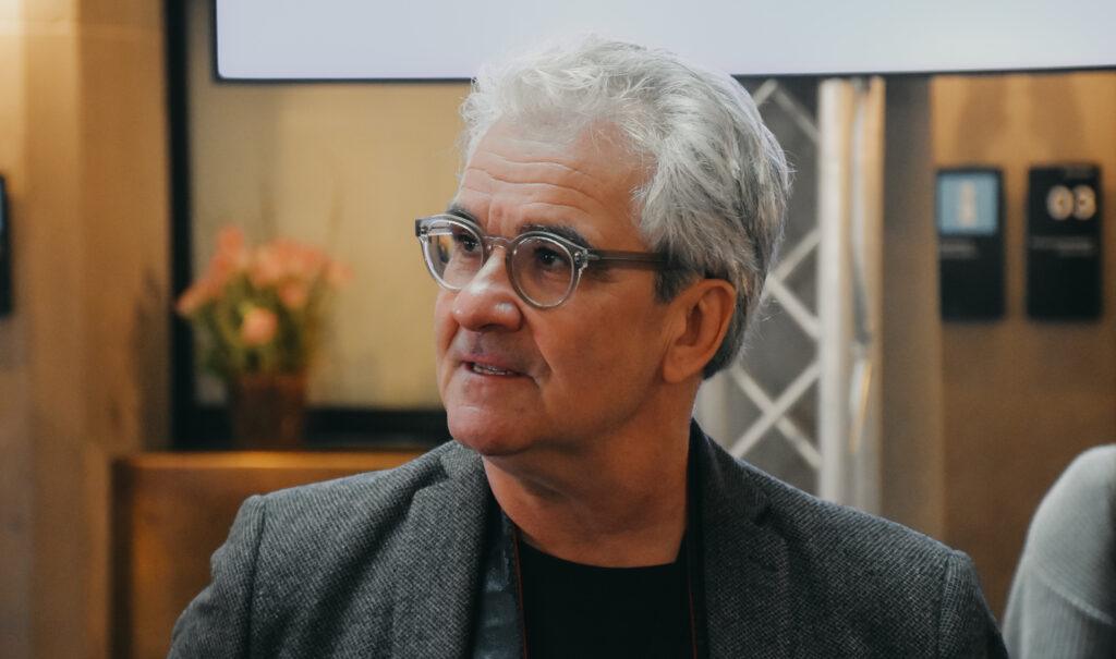 Lorenz Steinmann trägt ein graues Jackett. Er hat graue Haare und eine Brille.