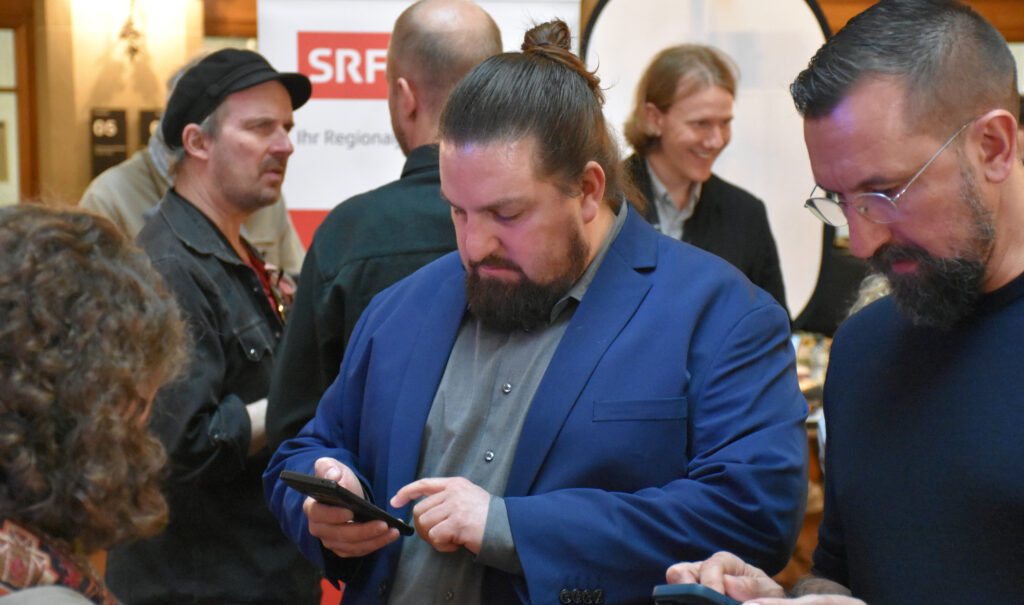 Ein Mann schaut angestrengt auf sein Handy.