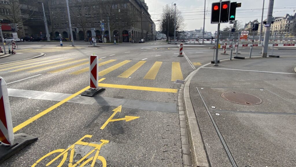 Zu sehen ist der von einer Autospur zu einer temporären Velospur umfunktionierte Fahrstreifen. Rechts die Ampel mit separater Anzeige für Velofahrende.