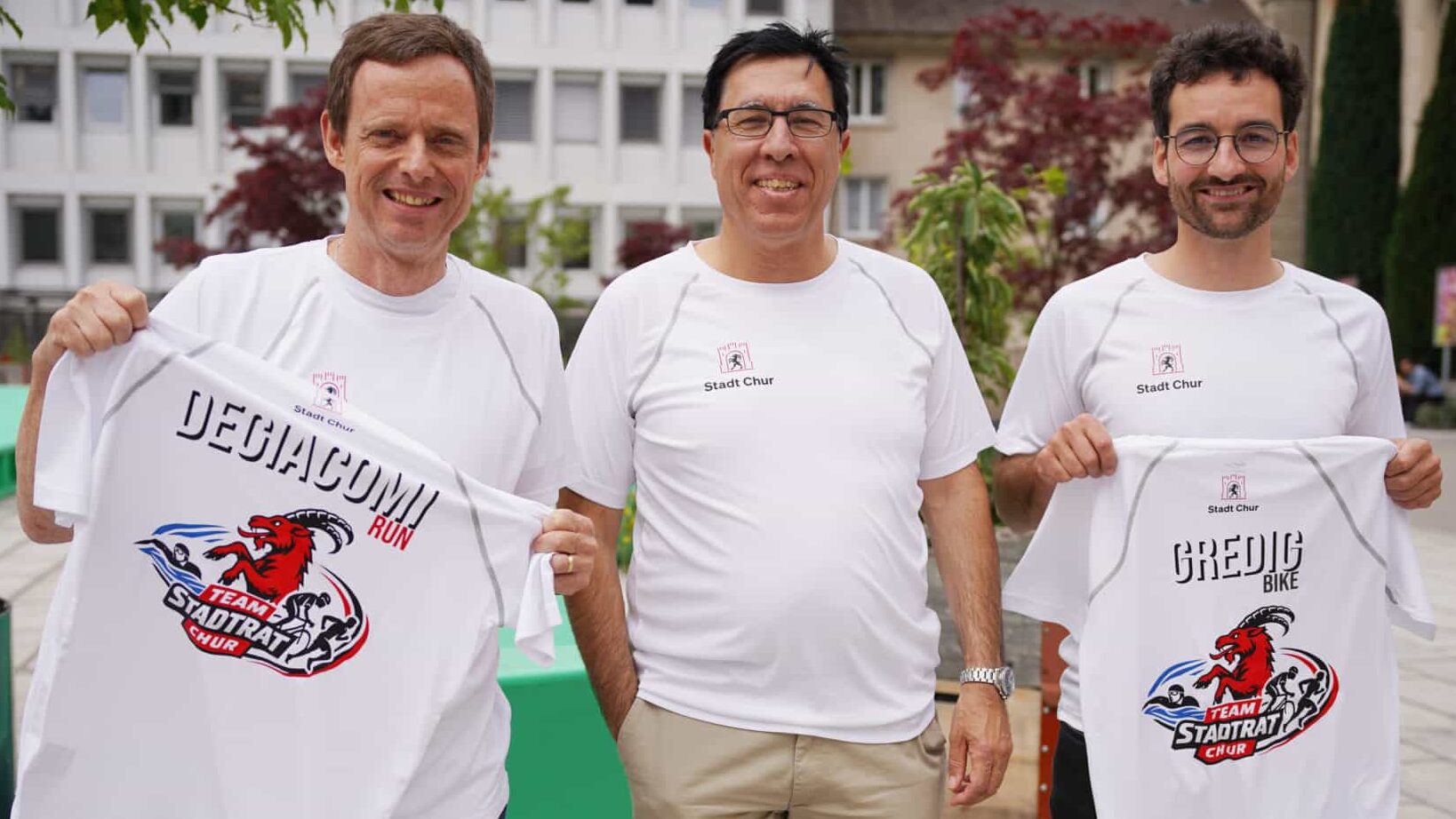Zu sehen sind die drei Stadtratsmitglieder von Chur, alle mit weissen Sportleibchen, passend für den kommenden Triathlon.