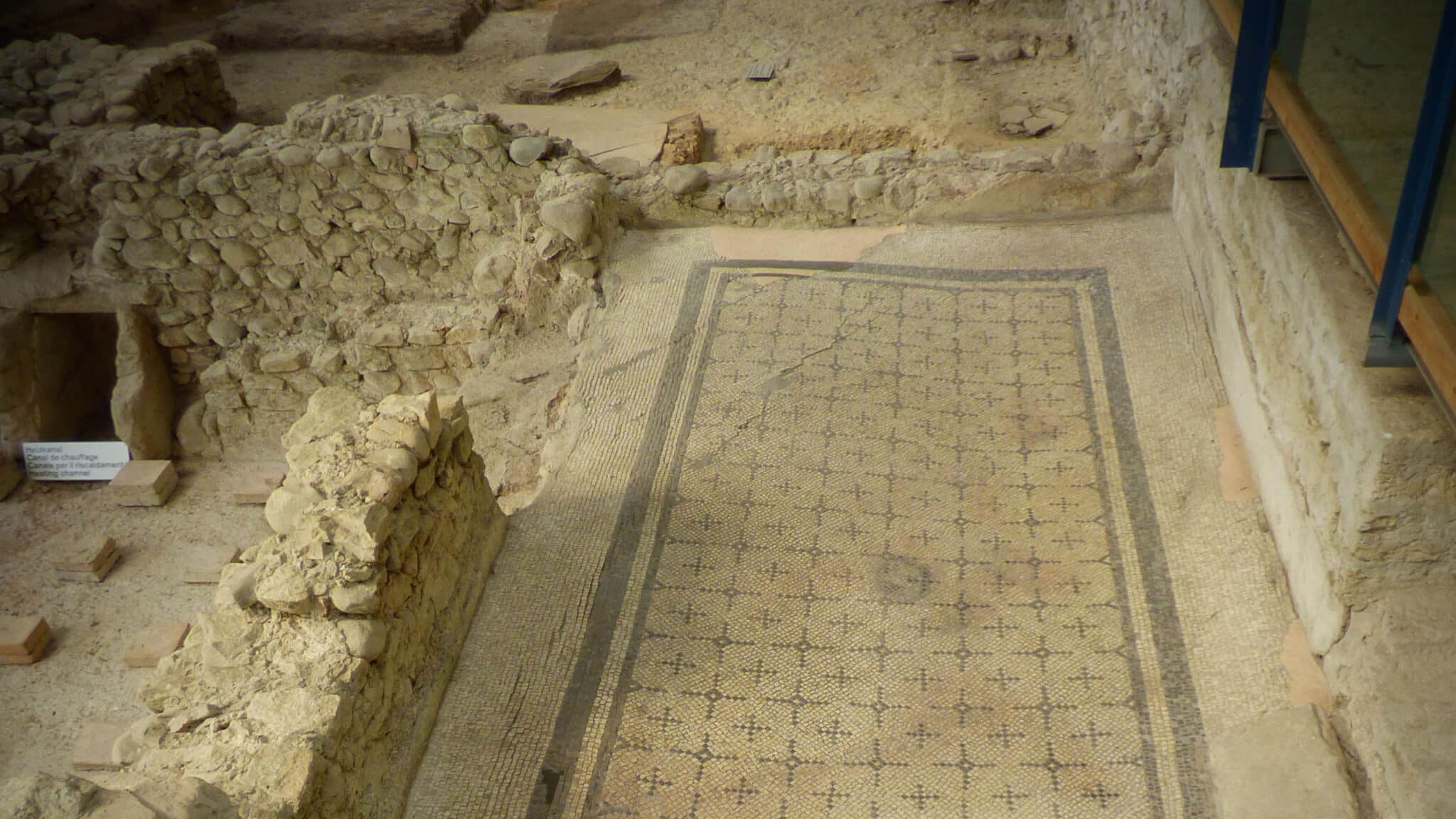 Archäologische Ausgrabung mit alten Mauern und einem Mosaikboden.