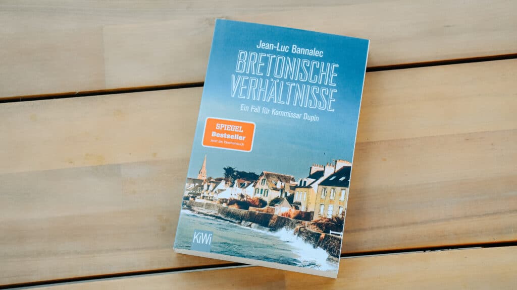 Das Buch "Bretonische Verhältnisse" von Jean-Luc Bannalec auf einem Holztisch.