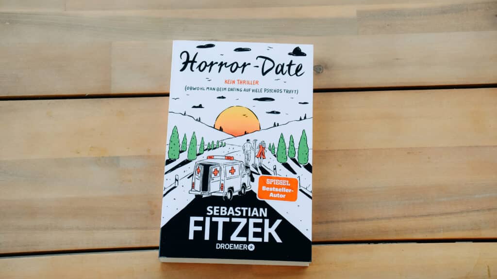 Das Buch "Horror-Date" von Sebastian Fitzek auf einem Holztisch.
