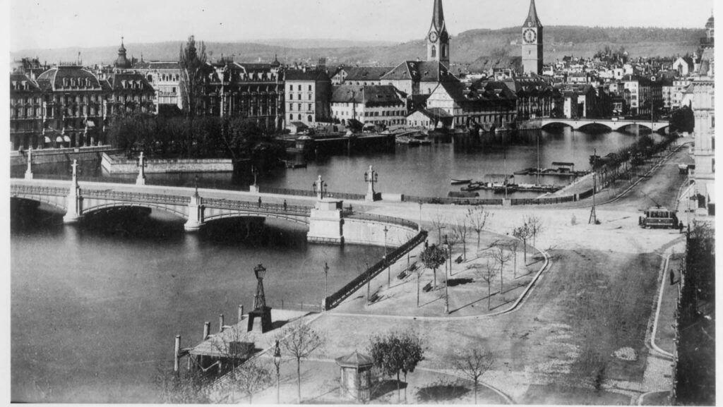 zu sehen ist ein historisches Foto von 1895 mit im Vordergrund dem Bellevue und der Quaibrücke. Von den im Artikel erwähnten Wurstständen ist natürlich noch nichts zu sehen.