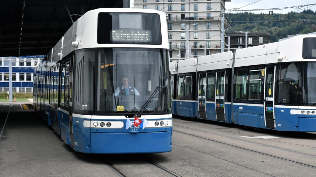 Blau-weisses Flexity-Tram mit kleinen Fahnen an der Front im Tramdepot.