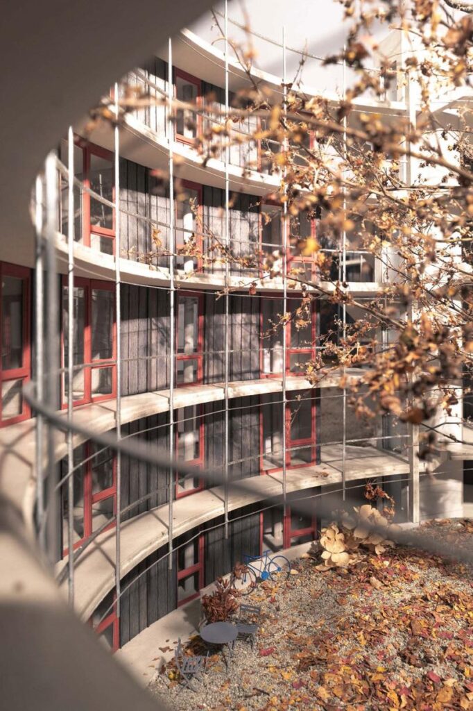 So schaut die Visualisierung aus: Halbrunde Bauten mit Balkonen, daneben einer der erhaltenen Bäume. Es ist Spätherbst.